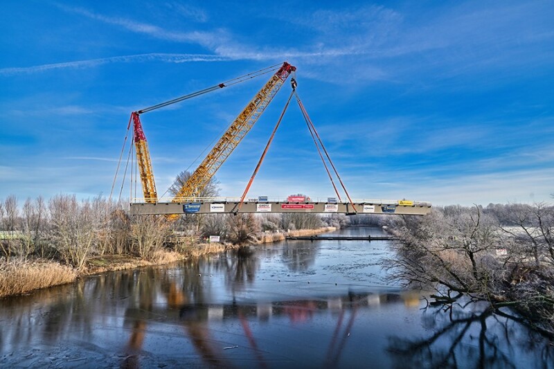 Kran hebt Brücke über den Kanal.