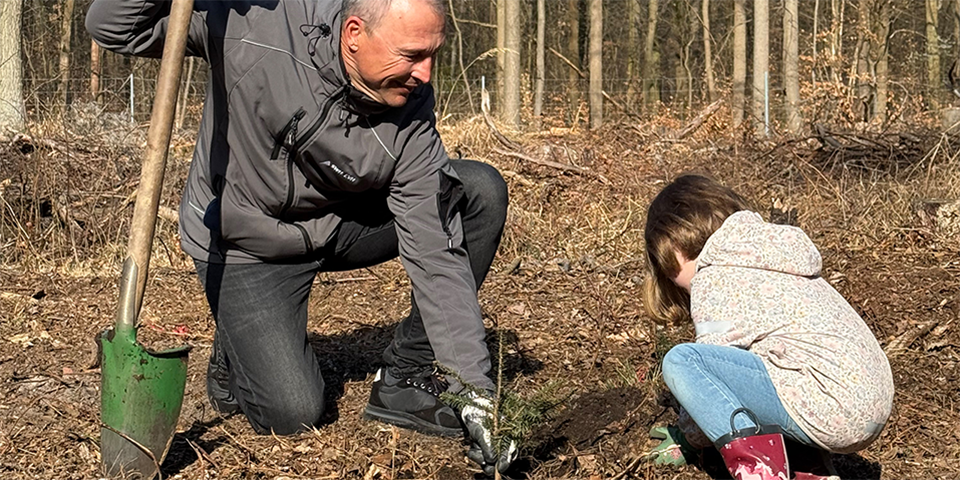 Olaf Schneider pflanzt einen Baum.