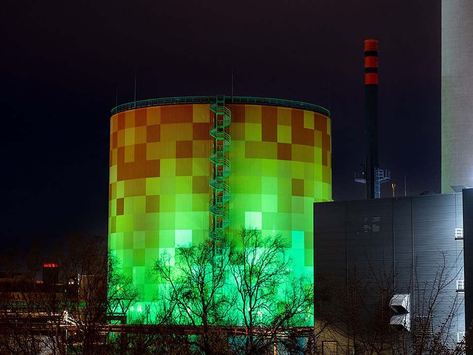 Der Energie- und Zukunftsspeicher im Energiepark Dieselstraße am Abend mit grüner Beleuchtung.