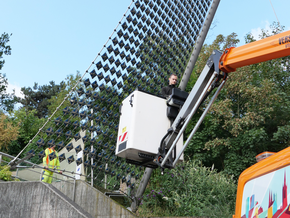 Solarsegel wird von einen Mitarbeiter der Energieversorgung Halle Netz von einem Steiger aus gereinigt