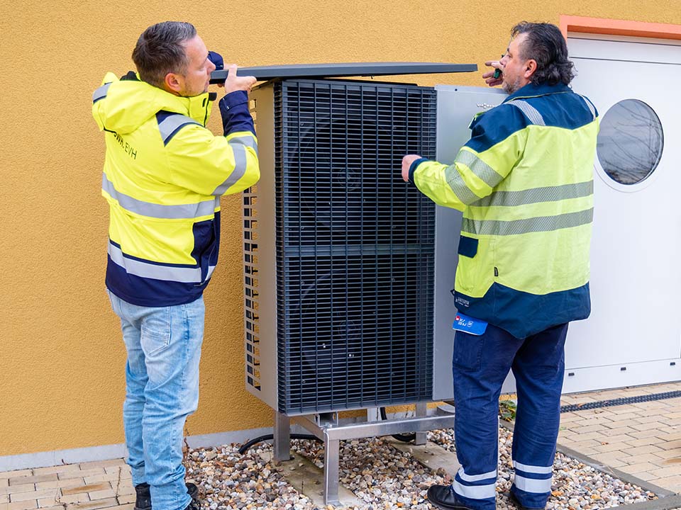 Eine Wärmepumpe wird von zwei Technikern gewartet