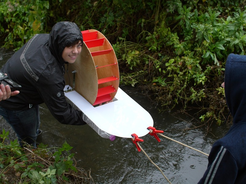 Schülerin testet an einem Wasserrad die Wasserkraft